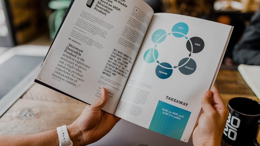 Empty coffee cup beside a laptop in a quiet workspace — waiting for a response that isn